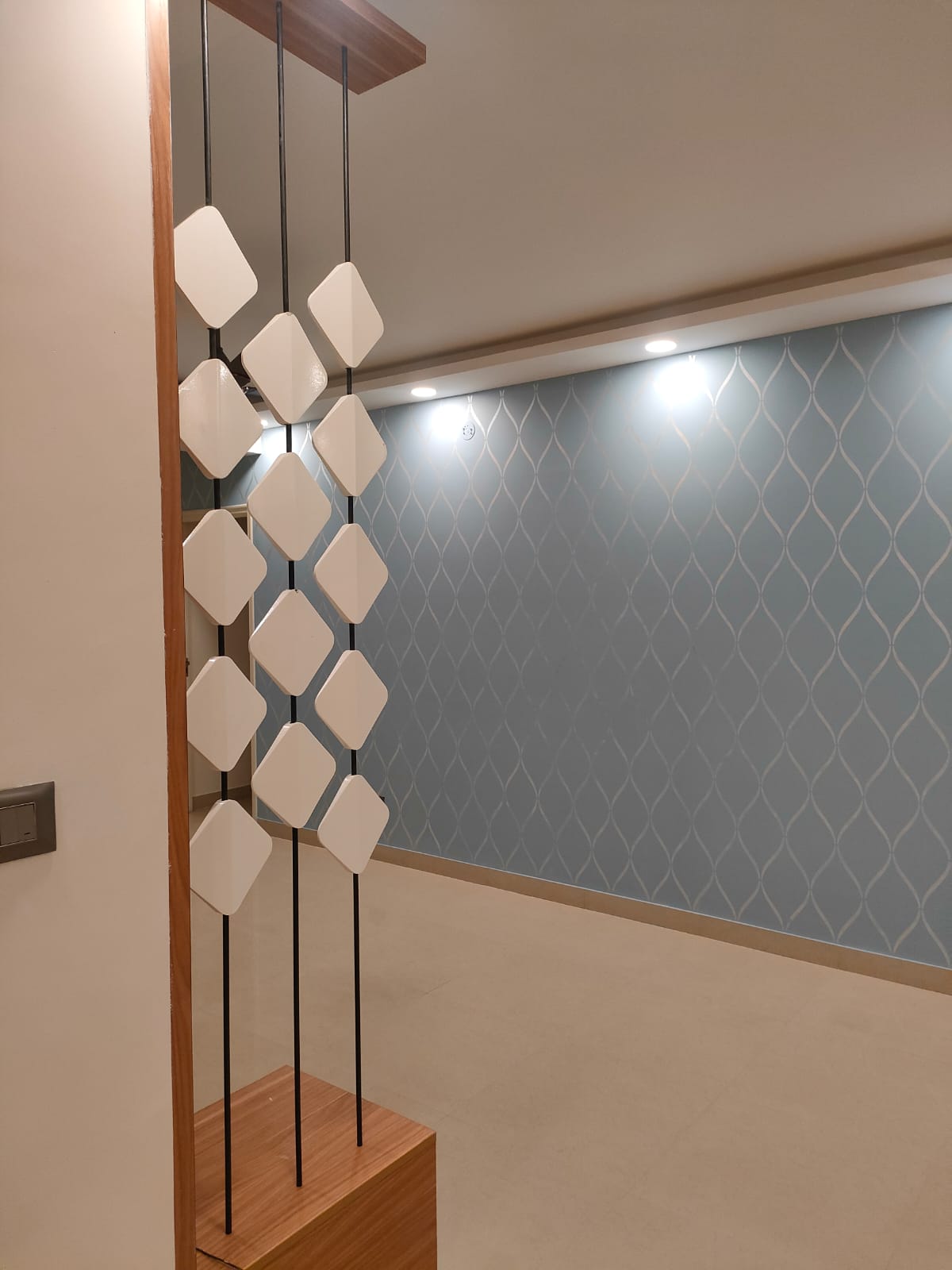 Entrance lobby with patterned wallpaper and a suspended pendant installation
