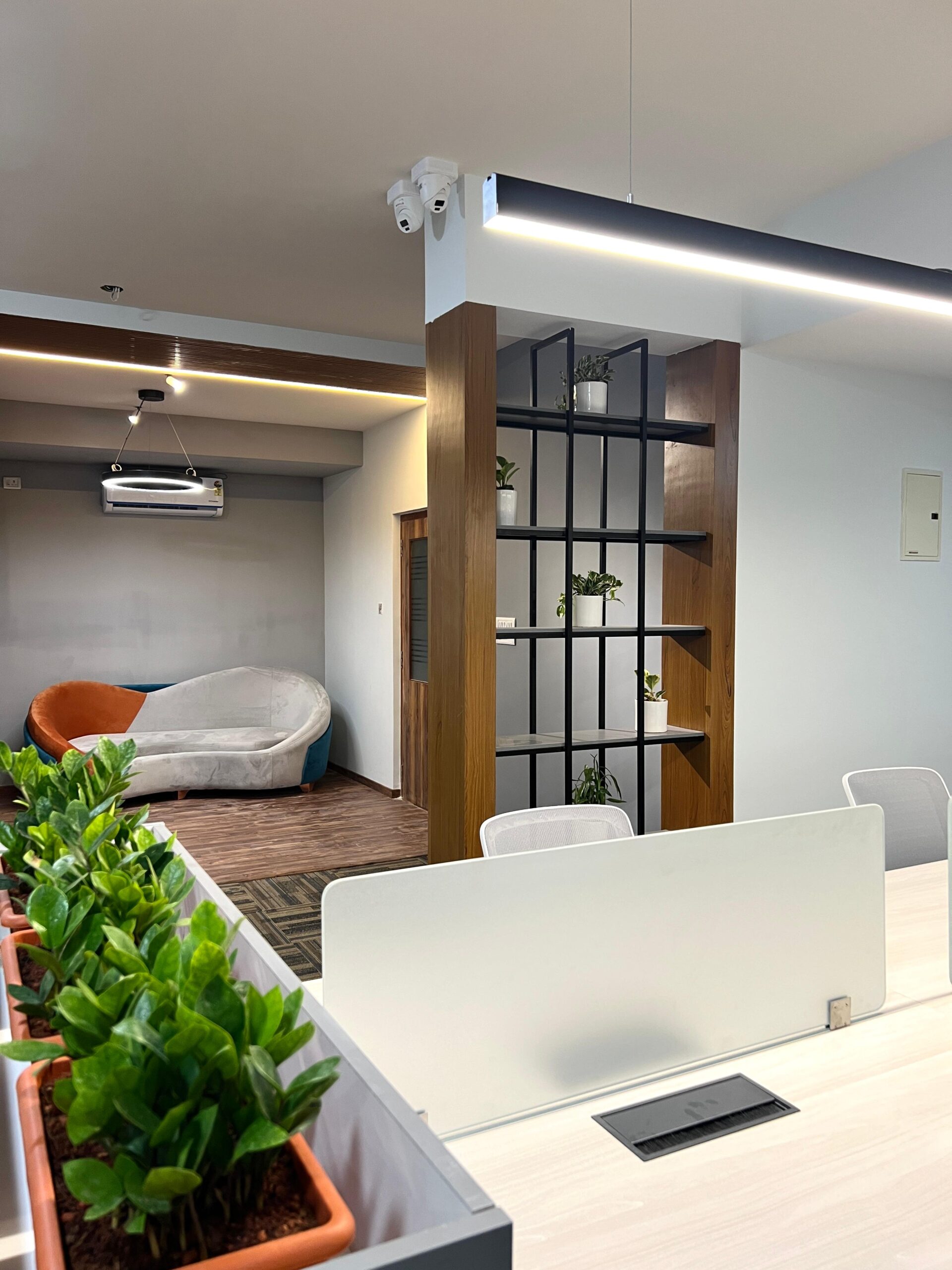 Breakout area with lounge seating, open metal shelving and timber-clad column