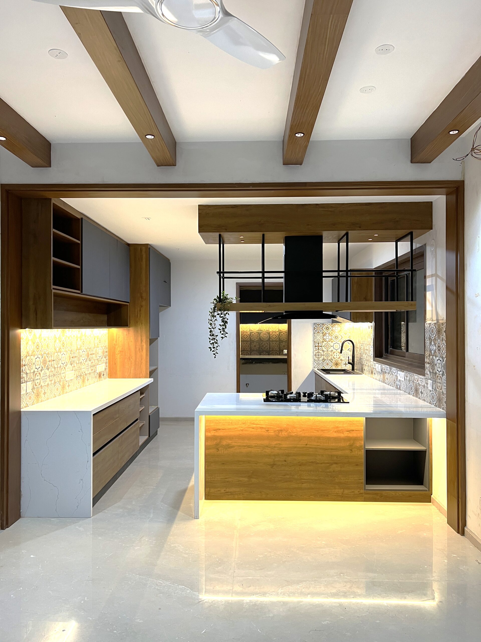 Modular kitchen with an island, patterned tile backsplash and exposed timber ceiling beams